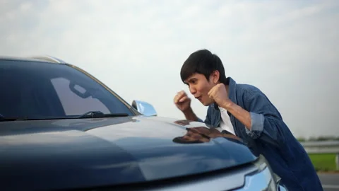 Surprised young handsome man getting the new car. He hugged his a car as a gift  Stock Footage 233233891