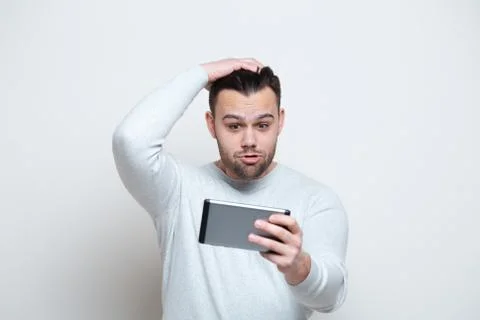Surprised young man using tablet over white background. Stock Photos