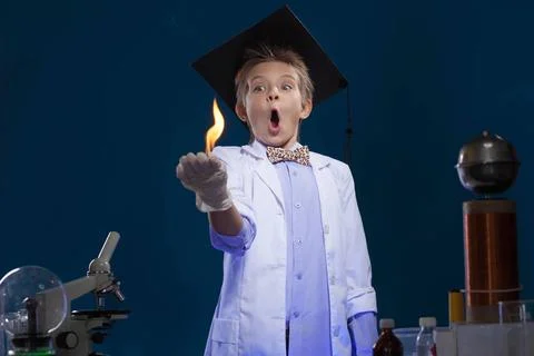 Surprised young physicist posing with fire in lab Surprised young physicis... Stock Photos