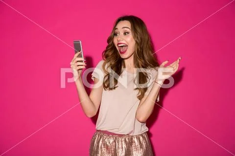 Surprised young woman chatting by phone. Stock Photos
