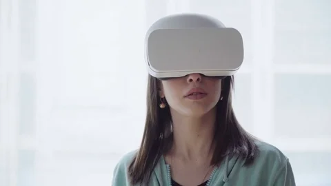 Surprized woman using virtual reality headset at home Stock Footage 74599989