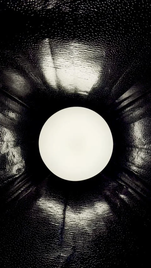 Surreal glowing white orb emerging from dark pebbled tunnel in dramatic monochro Stock Footage 327637275