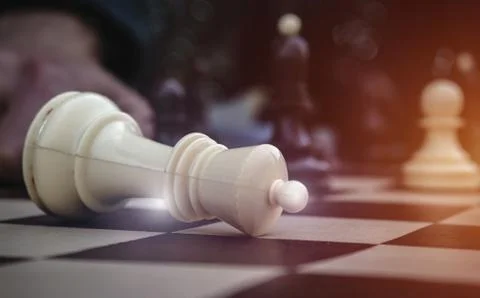 Surrender of king on chess board. White king down signifying a loss, close up. Foto stock