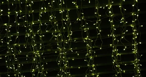 Surrounded by strings of twinkling fairy lights in a rustic indoor setting Stock Footage 302808798