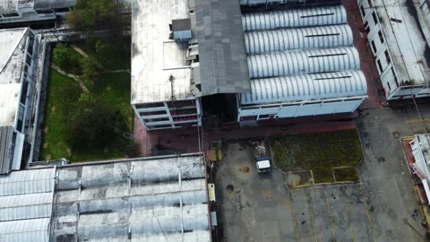 Surrounding the factory, a patchwork of warehouses and factories sprawls Stock Footage 273506987