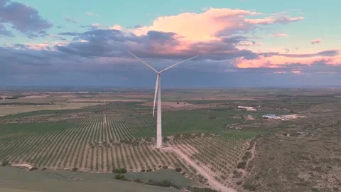 Surrounding an isolated wind turbine with its blades spinning Video stock 274528142