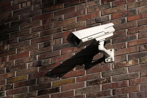 Surveillance and security camera installed on modern brick wall Foto stock