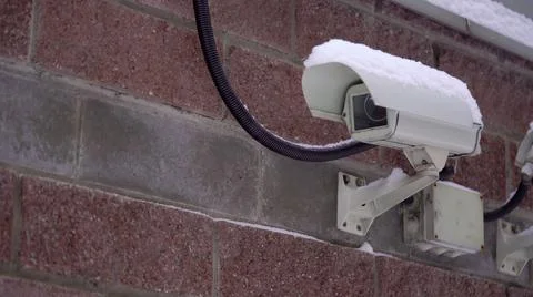 Surveillance and security CCTV camera on a city building wall, security system. Stock Photos