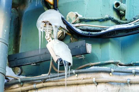 The surveillance camera is covered with a layer of ice and icicles. There is Stock Photos