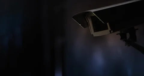 Surveillance camera in front of city lights at night Stock Footage