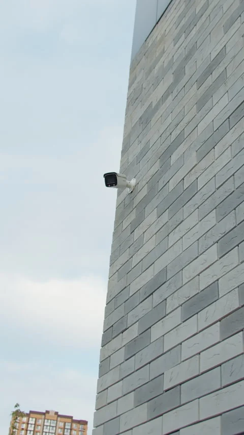 Surveillance camera on modern building wall against sky Stock Footage 320787754