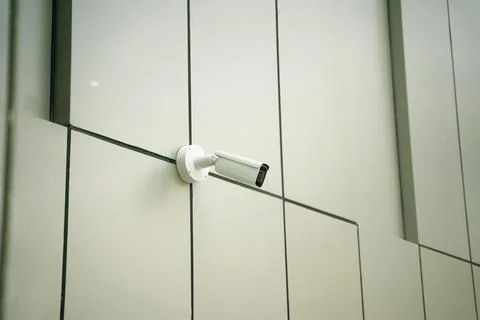 A Surveillance Camera is Mounted on a Modern Building Enhancing Safety and Stock Photos