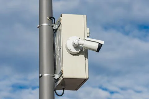 Surveillance camera mounted on a pole in a cloudy sky Photos