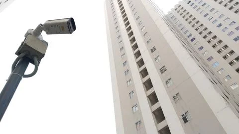 Surveillance Camera Mounted on Pole Overlooking Modern High-Rise Buildings. Stock Photos