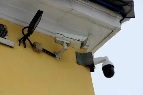 Surveillance camera mounted on tiled wall of house Stock Photos