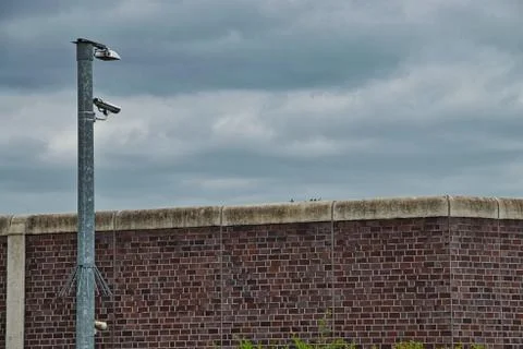Surveillance camera at a prison brick wall Foto stock