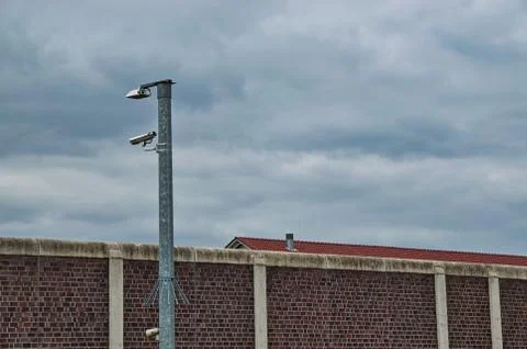 Surveillance camera at a prison brick wall Stock-Fotos