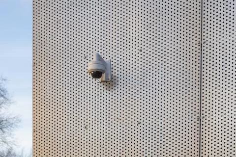 A surveillance security camera installed on the exterior wall of a building,  Stock Photos