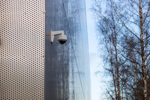 A surveillance security camera installed on the exterior wall of a building,  Stock Photos