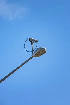 Surveillance security camera mounted on street lamp. Stock Photos