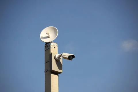 Surveillance system with an orange warning light located on a pole in the ope Stock Photos