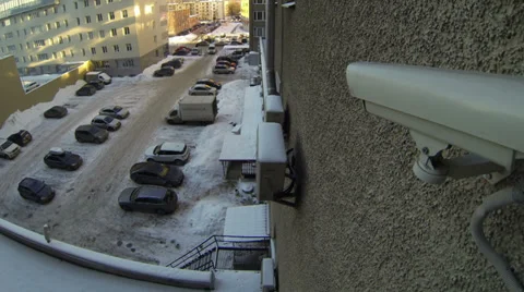 Surveillance video camera on wall looking at car parking lot Stock Footage 32354998