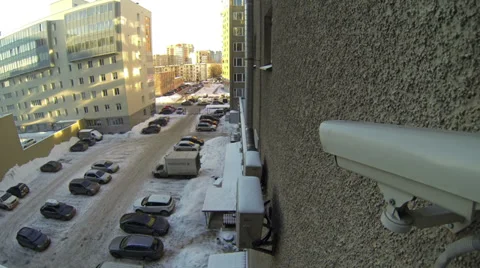 Surveillance video camera on wall looking at parking lot with vehicles Stock-Footage 32355076