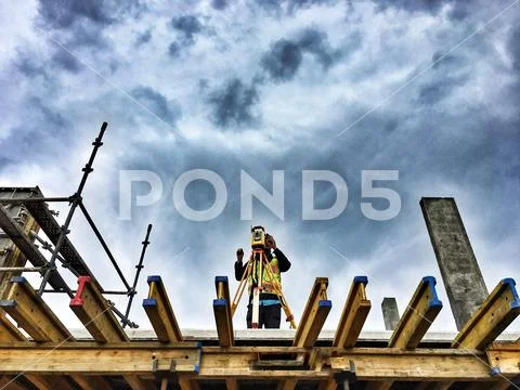 Surveyor on construction site with a robotic total station theodolite with dr Stock Photos