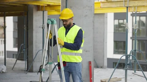Surveyor engineer setting up a theodolite on a tripod at a construction site Video stock 343450080