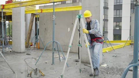 Surveyor installing theodolite tripod on construction site Video stock 337469856
