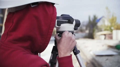 Surveyor with leveler explores construction site Stock Footage 165820703