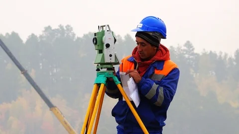 Surveyor performs measuring operations on the level and the theodolite Stock Footage 74109383