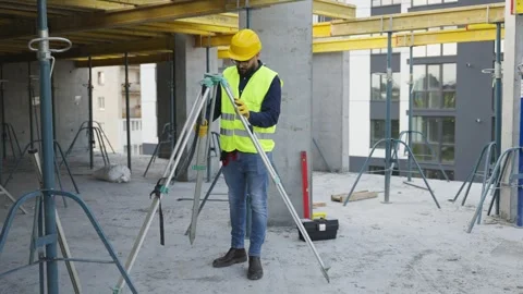 Surveyor setting up theodolite on construction site Video stock 343450040