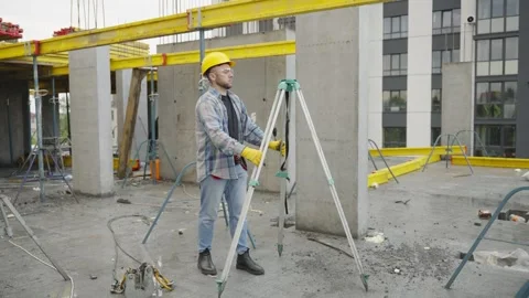 Surveyor using optical level theodolite at construction site Stock Footage 337469591