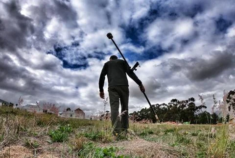 Surveyor walking with GPS with dramatic clouds measuring topography Stock Photos