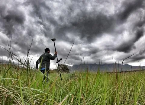 Surveyor walking with GPS with dramatic clouds measuring topography Stock Photos