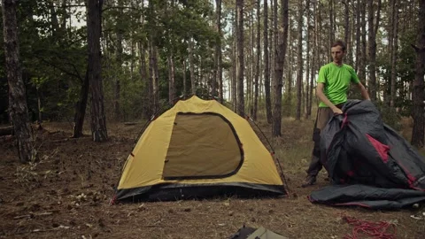 A survivalist sets up a tent in the forest. Stock Footage 161961701