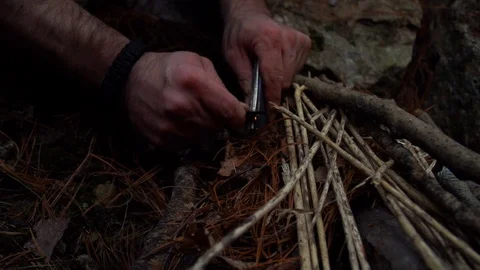Survivalist Starting Fire with Flint and Steel in the Woods Video stock 124298317