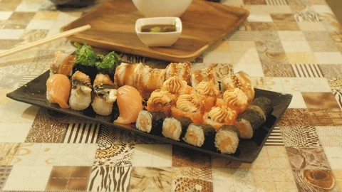 Sushi and rolls are set on the table the camera approach Stock Footage 121404375