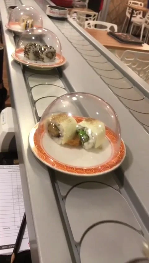 Sushi And Rolls On Plates Moving Around A Sushi Bar Stock Footage 219734009