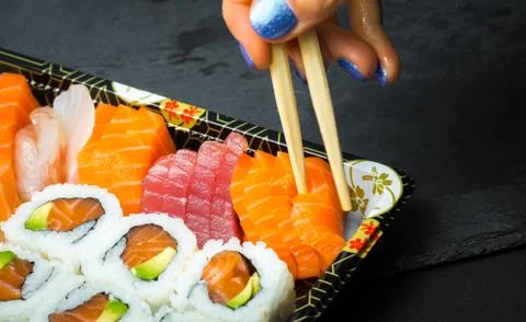 Sushi and Sashimi rolls on a black stone slatter. Fresh made Sushi set with s Stock Photos