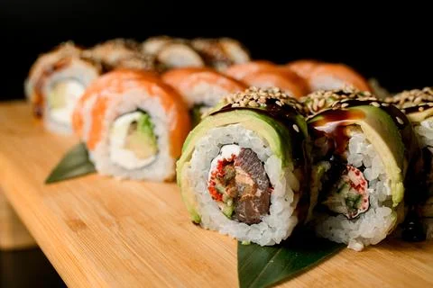 Sushi assorted on a thick board with curd cheese, tuna, salmon, sesame and 스톡 사진