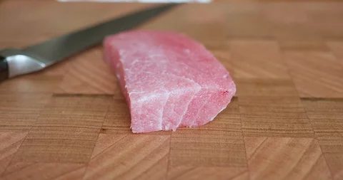 Sushi chef cuts thin slices of fatty belly tuna, also called toro, chutoro Video stock 114776992