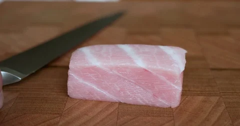 Sushi chef cuts thin slices of fatty belly tuna, also called toro, otoro Stock-Footage 114800867