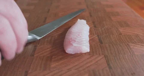 Sushi chef cuts thin slices of gurnard, also called red gurnard 库存影片 115529675