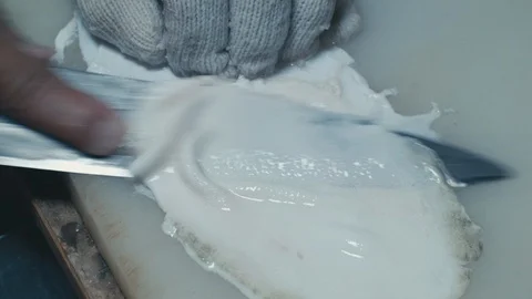 Sushi Chef cutting thin slices of skin off Fugu fish on white chopping Stock Footage 105294703