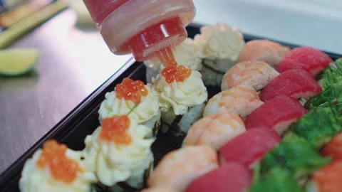 A sushi chef decorates and decorates a sushi set with various toppings. Stock Footage 331865350