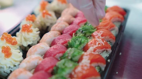 A sushi chef decorates and decorates a sushi set with various toppings. Vídeos de archivo 331865474