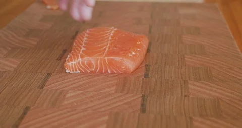 Sushi chef picks up a knife and cuts thin slices of fatty belly salmon for Japan Stock-Footage 114738997