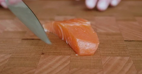 Sushi chef picks up a knife and cuts thin slices of fatty belly salmon for Japan Stock-Footage 114770448